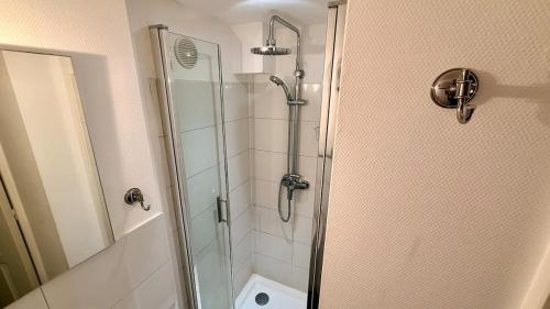 a bathroom with a shower with a glass door at Les Cimes au cœur du Massif du Sancy in Le Mont-Dore