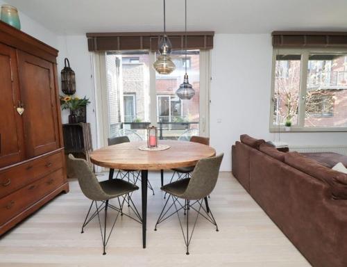 a kitchen with a table and chairs and a couch at Spacious apartment in the heart of the city center with parking space in Breda