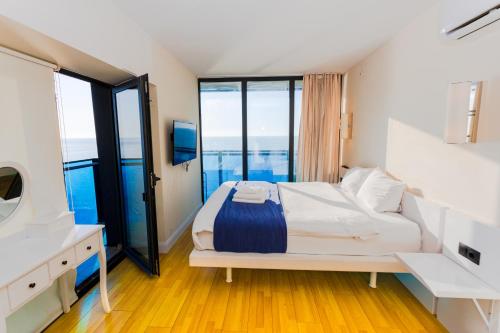 a bedroom with a large bed and a balcony at PANORAMA In Orbi complex central Hotel in Batumi