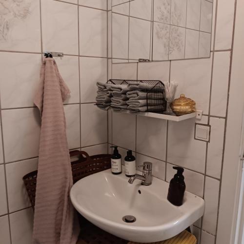 a bathroom with a sink and a towel on a shelf at Bøelgaarden in Gørding