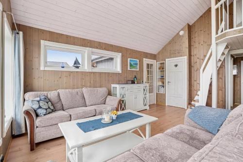 a living room with a couch and a table at Hytte ved havet på Brensholmen, nær Sommarøy, Tromsø in Tromsø