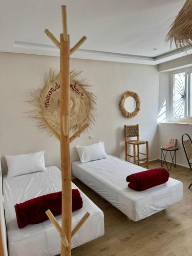 a room with two beds and a cross on the wall at Maison Mira in Rabat