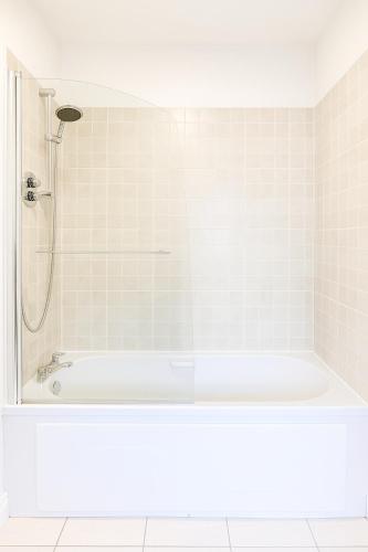 a white bathroom with a shower and a tub at Guinness and Grafton city stay in Dublin