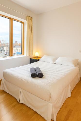 a bedroom with a large white bed with two slippers on it at Guinness and Grafton city stay in Dublin