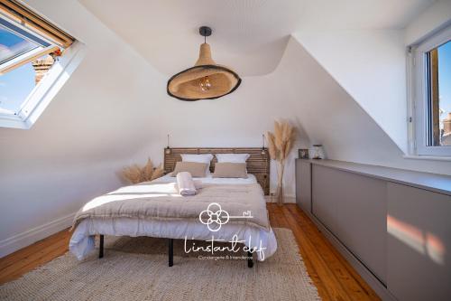 ein Schlafzimmer mit einem Bett und einer Hängeleuchte in der Unterkunft Havre de paix avec jacuzzi - Hyper-centre du Mans in Le Mans