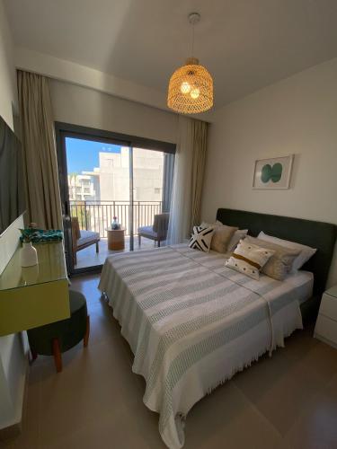 a bedroom with a large bed and a balcony at 4 Bedrooms Penthouse Villa, Marassi in El Alamein