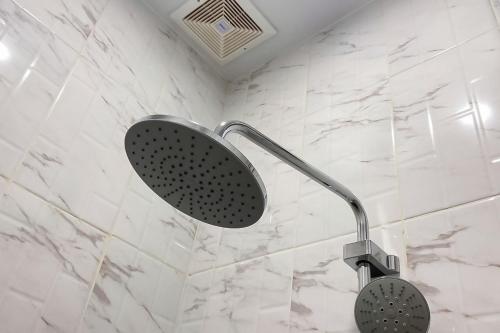 a shower with a shower head in a bathroom at Homestay Zahra Syariah Gunung Dempo Mitra RedDoorz in Lahat