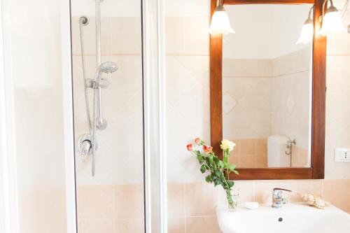 a bathroom with a sink and a shower with a mirror at Orlando Bayview in Balestrate