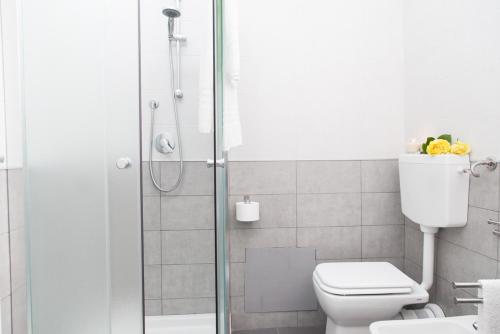 a bathroom with a toilet and a glass shower at Orlando Bayview in Balestrate