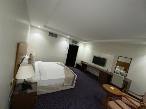 a hotel room with a bed and a television at فندق دولف الخبر in Al Khobar