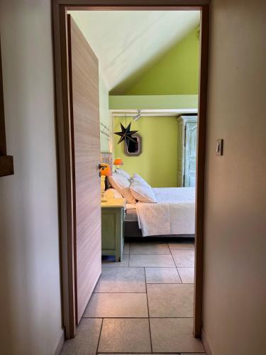 a bedroom with a bed in a room with green walls at Gîte de la Valière in Chevigny-en-Valière