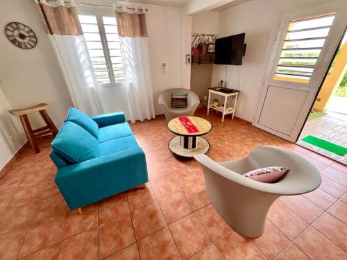 a living room with a blue couch and a chair at Charmant T3 en RDJ chez Ketty à Ducos in Ducos