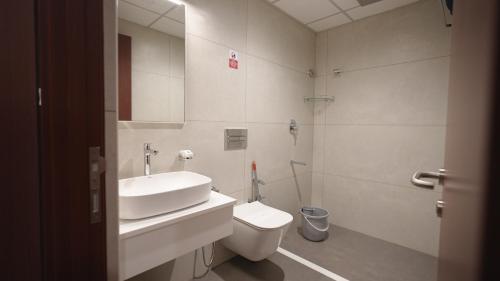 a bathroom with a sink and a toilet and a shower at AS Suites in Cochin