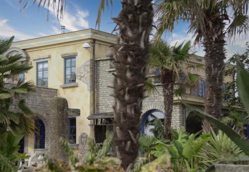 an old house with palm trees in front of it at Boutique Villa De Zuilen in Hillegom