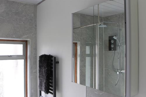 a shower with a glass door in a bathroom at The Summerhouse, Uig, Skye in Uig
