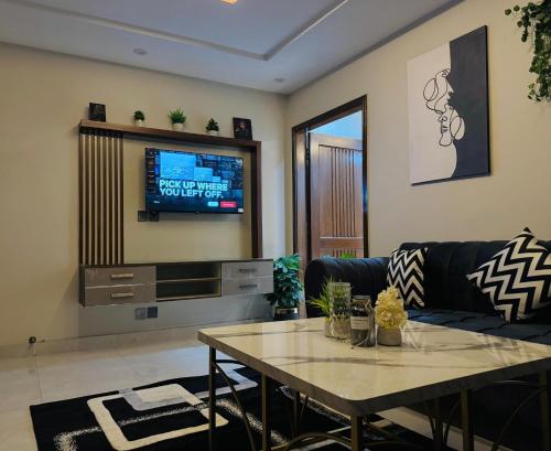 una sala de estar con un sofá y una mesa en Osma Living Apartment Lahore, en Lahore