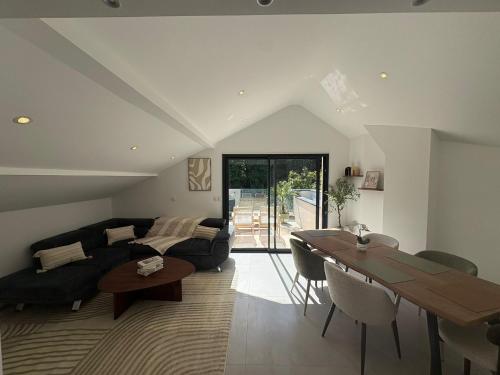 a living room with a couch and a table at Aix-les-Bains T3 haut standing écrin de calme avec jacuzzi en supplément in Saint-Simon