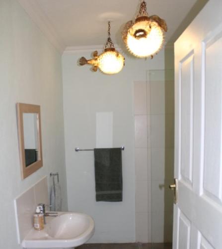 a white bathroom with a sink and a mirror at Woburn Guest House in Chartwell