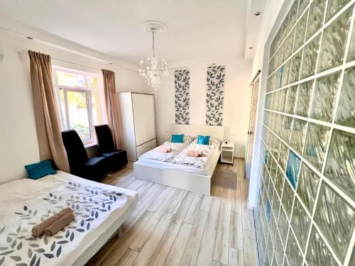 a bedroom with two beds and a chair in it at Füredi Virág Villa in Balatonfüred