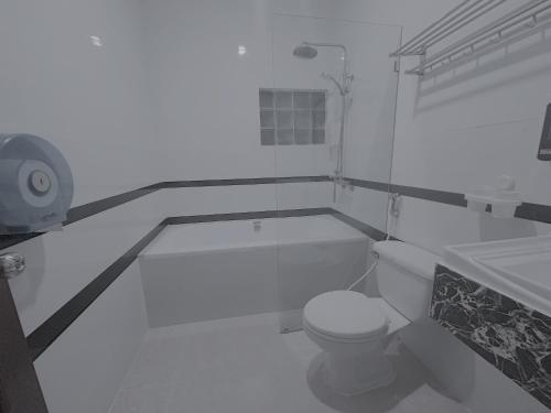 a white bathroom with a toilet and a sink at Villa Mahasok hotel in Luang Prabang