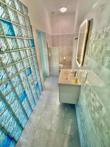 a bathroom with a sink and a mirror at Füredi Virág Villa in Balatonfüred