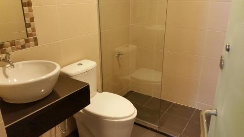 y baño con aseo, lavabo y ducha. en Hotel Iskandar en Kota Kinabalu