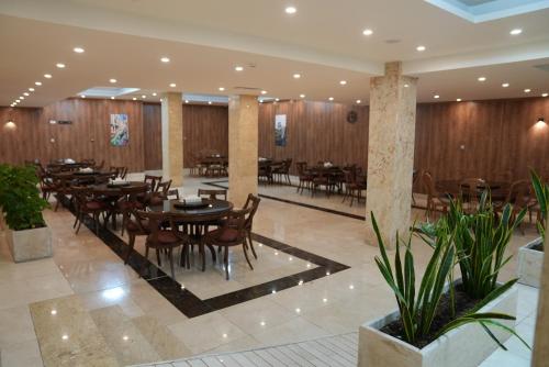 un restaurante con mesas, sillas y paredes de madera en فندق قصر الخورنق, en Nayaf