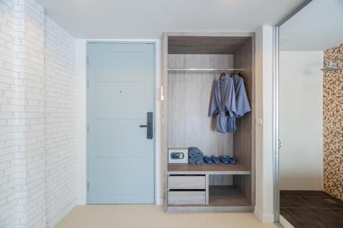 a walk in closet with a glass door at MORE Patong Hotel in Patong Beach
