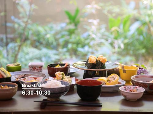 京都市にあるホテル ザ セレスティン京都祇園  のさまざまな種類の食べ物をボウルに入れて載せたテーブル