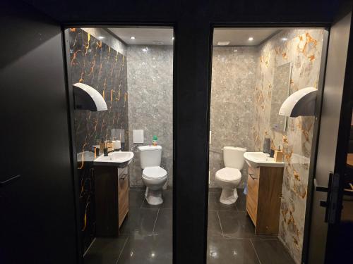 La salle de bains est pourvue de 2 toilettes, de 2 lavabos et de miroirs. dans l'établissement LoftHouseClub, à Varsovie
