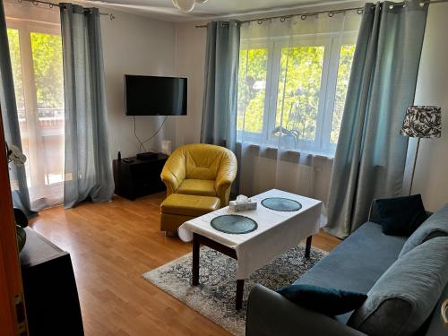 a living room with a couch and a table and a chair at Kasztanowa Apartament in Warsaw