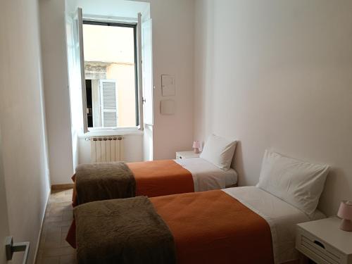 two beds in a small room with a window at Alloggio Turistico Corso Italia 74 Viterbo in Viterbo