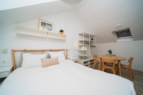ein Schlafzimmer mit einem großen weißen Bett und einem Tisch in der Unterkunft Blu Riva Hvar in Hvar