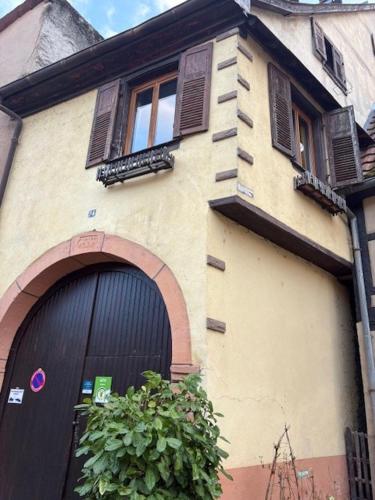 ein Gebäude mit einem großen Tor und einer Tür in der Unterkunft La Colombe in Beblenheim