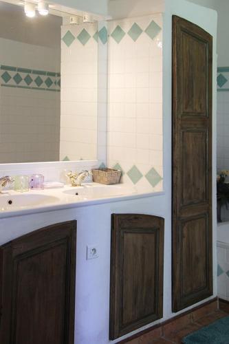 a bathroom with a sink and a mirror at Maison d'hôtes Ferme de la Commanderie in Richerenches