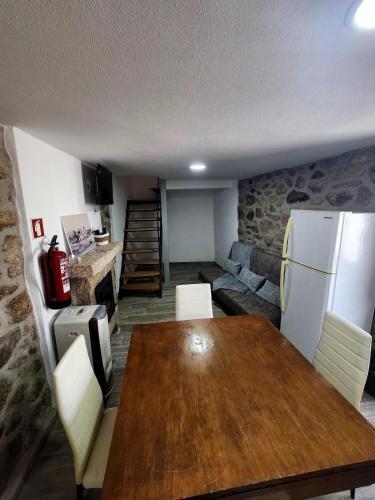 a living room with a wooden table and a couch at A Casa da Aldeia 1 Belmonte in Gaia