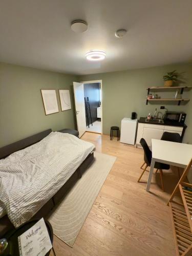 a bedroom with a bed and a table and a desk at Modern 1-room apartment - right by the Arctic Cathedral and Fjellheisen in Tromsø