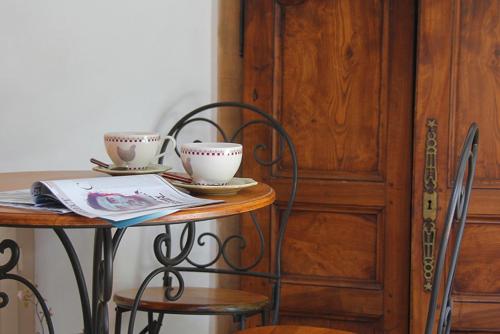 a table with two cups on top of it next to a door at Maison d'hôtes Ferme de la Commanderie in Richerenches