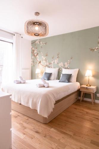 a bedroom with a large bed and a chandelier at Appart Le Lully in Versailles