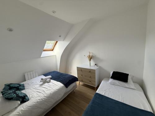 a bedroom with two beds and a dresser at Le Voyageur - 7 p - Circuit Rêve au Mans in Écommoy