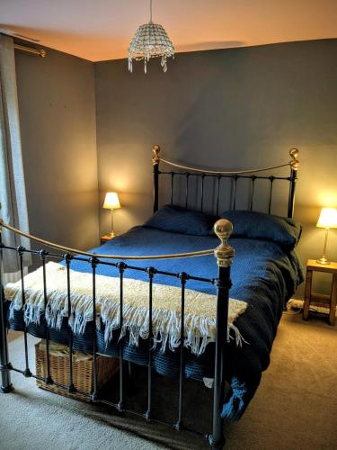 a bedroom with a black bed with blue sheets at 7 dodds lane alnwick in Alnwick