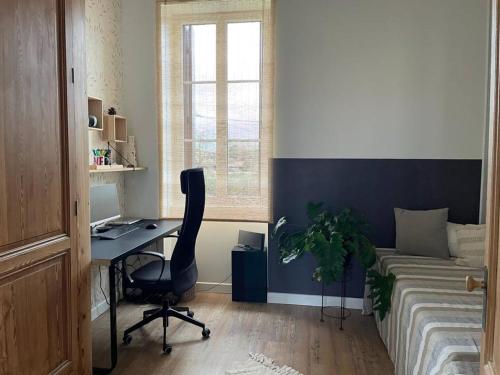 a bedroom with a desk and a bed and a window at Chambres au cœur des vignes in Saint-Christoly-Médoc