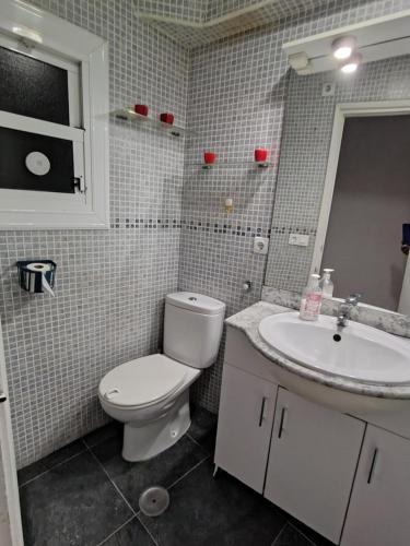 a bathroom with a toilet and a sink at Hogar in Alicante