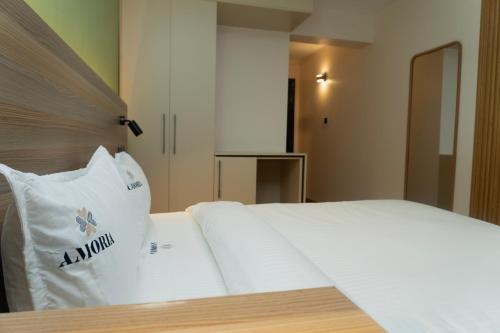 a white bed with a pillow on top of it at Amoria Boutique Hotel in Kiambu