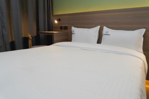 a large white bed in a hotel room at Amoria Boutique Hotel in Kiambu