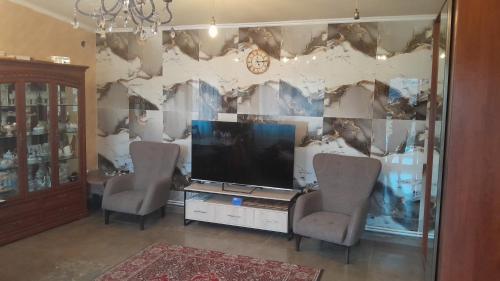 a living room with two chairs and a television at Агарод in Atʼarbekyan
