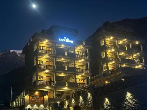 un bâtiment avec un panneau dessus la nuit dans l'établissement The face resort, à Muktināth