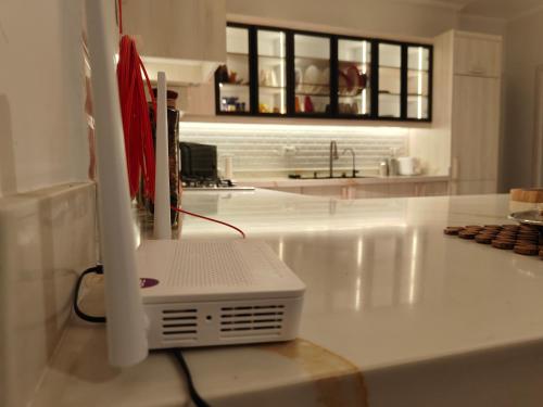 a computer sitting on a counter in a kitchen at Chic Boho Vibes Apart -Smart Home 2BR - New Cairo - Family only retreat in New cairo