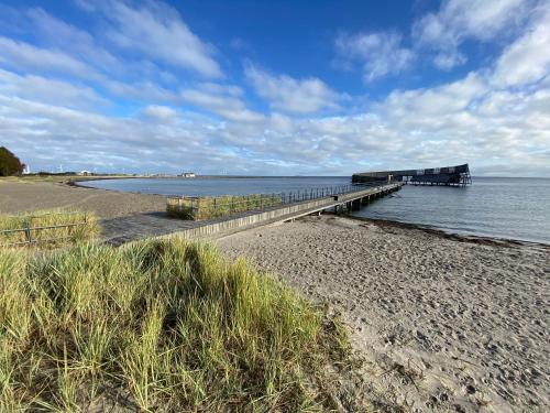 a pier on a beach next to the water at CPH Airport Room - 1 min to train, 15 min to City Center in Copenhagen
