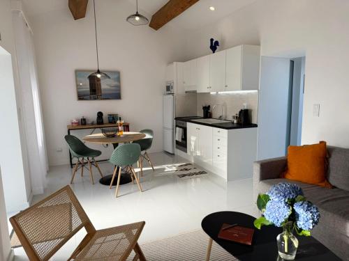 a living room and kitchen with a couch and a table at Casa Amélia in Feteira Grande